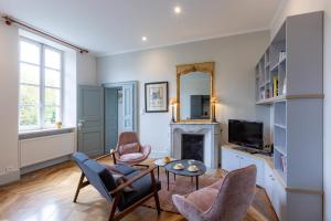 a living room with a fireplace and chairs and a table at Le Pigeonnier in Embrun