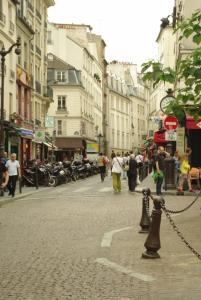 eine Gruppe von Menschen, die eine Stadtstraße entlang laufen in der Unterkunft Studio Rue Lacépède in Paris