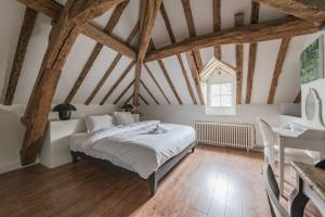een slaapkamer met een bed in een kamer met houten balken bij Standing cottage in Disneyland in Chalifert