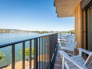 a balcony with two chairs and a view of the water at PAPA RHEIN - Hotel & Spa in Bingen am Rhein