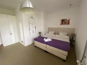 1 dormitorio con 1 cama y reloj en la pared en De Slaapfabriek vakantiehuis en trainingslocatie, en Teuge