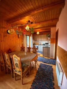 ein Esszimmer mit einem Tisch und Stühlen sowie eine Küche in der Unterkunft Chata Zuzana in Terchová