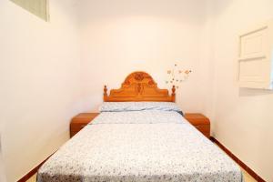um quarto com uma cama e uma cabeceira em madeira em Global Properties, Adosado en la playa de Almardá, Sagunto em Sagunto
