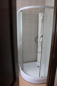 a shower with a glass door in a bathroom at Русь Отель in Kolpino