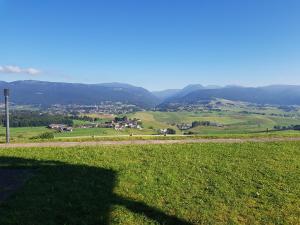 a shadow of a person on a field with mountains in the background at Chalet bellevue in Asiago