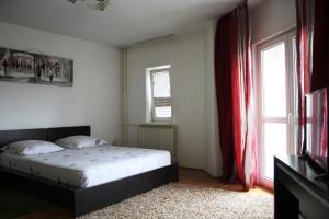 a bedroom with a bed and a window at Decebal 1 Premium apartment in Bucharest