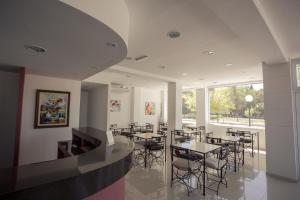 Un restaurante con mesas y sillas y un gran ventanal. en Hotel Lavalle, en General Lavalle