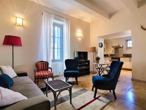 a living room with a couch and chairs and a table at Appartement avec terrasse en centre ville de Saint Remy de Provence in Saint-Rémy-de-Provence