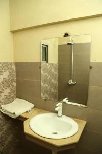 a bathroom with a sink and a mirror at Hotel Bilal in Karachi