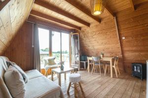 a living room with wooden walls and a table and chairs at la ferme des epis in Ouffières