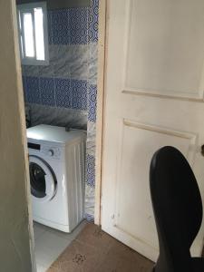 Waschmaschine und Trockner in einem Zimmer mit Tür in der Unterkunft Sumanguru Guest House- GATEWAY TO THE AIRPORT in Busumbala