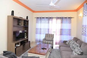 een woonkamer met een bank en een salontafel bij M Luxury Apartments O2. in Mombasa