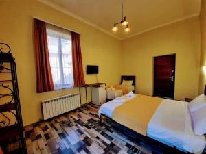 a hotel room with two beds and a television at Green Flower Hotel in Kutaisi