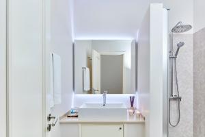 a white bathroom with a sink and a shower at Ancão Gardens in Quinta do Lago