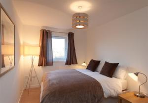 سرير أو أسرّة في غرفة في The Lochend Park View Residence