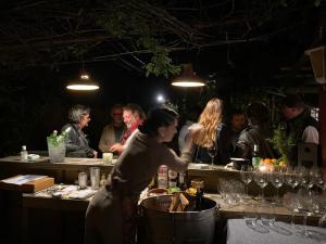 a group of people standing around a bar with wine glasses at Posada Paradiso in José Ignacio