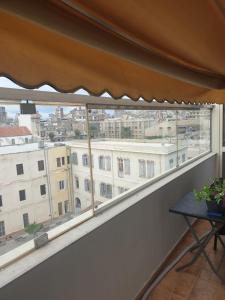 een balkon met een tafel en uitzicht op de stad bij Alexander The Great Hotel in Alexandrië