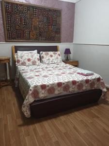 a bedroom with a bed with a floral bedspread and pillows at Alexander The Great Hotel in Alexandria