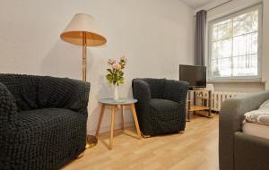 - un salon avec deux chaises et une table fleurie dans l'établissement Hüblers-Schlafquartier, à Fürstenwalde