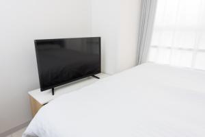 a flat screen tv sitting on top of a table at COCOSTAY Global Noboricho4F ココステイ グローバル ノボリチョウ4F in Hiroshima
