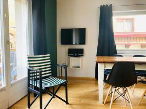 comedor con sillas, mesa y TV en Alpensoul Apartments, en Zell am See
