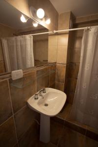 y baño con lavabo blanco y ducha. en Hotel Lavalle en General Lavalle