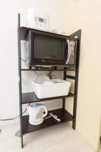 a microwave oven sitting on top of a shelf at COCOSTAY Global Noboricho4F ココステイ グローバル ノボリチョウ4F in Hiroshima