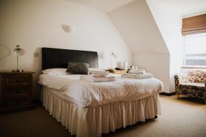 een slaapkamer met een groot bed en handdoeken bij The Stratton House Hotel in Biggleswade