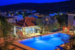 a swimming pool in front of a house at night at Apartment Zeljana in Slatine
