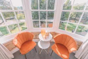 a room with a table and two chairs and windows at Old Bank Rooms in Bourton on the Water