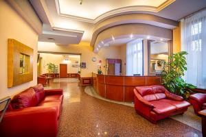 um átrio com dois sofás de couro vermelho e um tribunal em Hotel Fenix em Jelenia Góra