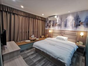 1 dormitorio con 1 cama grande y TV en Jieyang Yunduo Hotel (Chaoshan Airport) en Jieyang