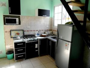a kitchen with a refrigerator and a stove at Las golondrinas in San Clemente del Tuyú