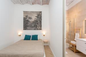 sypialnia z łóżkiem z niebieskimi poduszkami w obiekcie Canela Homes BARCELONA MARINA w Barcelonie
