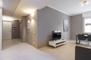 ein Wohnzimmer mit einem TV und einem Tisch in der Unterkunft Contempora Apartments - Cavallotti 13 - B62 in Mailand