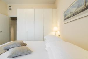 a bedroom with a white bed with two pillows at Contempora Apartments - Elvezia 8 - E24 in Milan