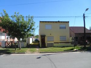 una casa amarilla al lado de una calle en Las golondrinas en San Clemente del Tuyú