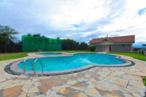 a large swimming pool with a flagstone patio and anergynergynergynergyhews at Mtoni Resort, Naro moru in Naro Moru