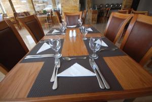 een lange houten tafel met glazen en servetten erop bij Sharah Mountains Hotel in Wadi Musa
