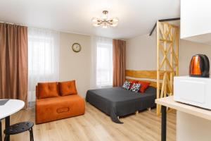 a small bedroom with a bed and a chair at EtazhiDaily at Yumasheva in Yekaterinburg