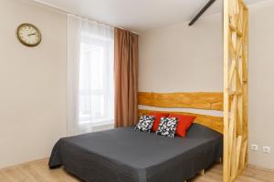 1 dormitorio con 1 cama con almohadas rojas y negras en EtazhiDaily at Yumasheva, en Yekaterinburg