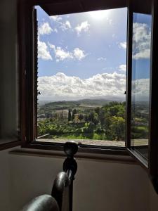 a window with a view of the countryside through it at Nero Gioconda in Anghiari