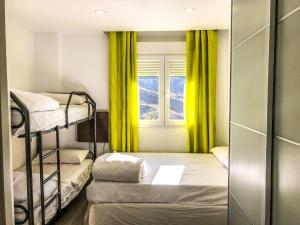 Pokój z 2 łóżkami piętrowymi i oknem w obiekcie Apartamentos Sierra Nevada Prime Bluettravel w mieście Sierra Nevada