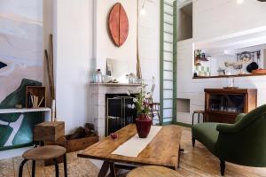 a living room with a table and a fireplace at Logement Design à Loix-en-Ré - 2 étoiles - Centre Village in Loix