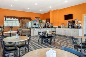 a restaurant with tables and chairs and a kitchen at ASAM Hotel in Goodland