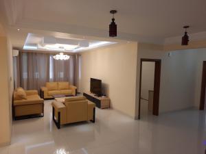 a living room with a couch and a tv and chairs at Haut standing Appartement F5 meublé à Dakar Ngor virage in Dakar