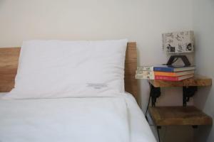 un lit avec une pile de livres sur une table de chevet dans l'établissement Apartmani Sanja, à Zlatibor