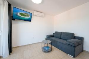 uma sala de estar com um sofá e uma televisão de ecrã plano em Feel Dugi otok apartments em Luka