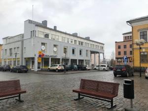 a large white building with cars parked in a parking lot at Hostel400Kokkola Extend in Kokkola