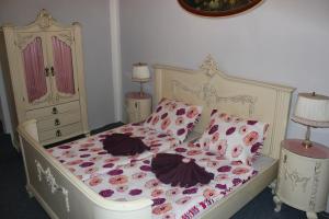 a bedroom with a white bed with flowers on it at Hotel Corrado in Ostrava